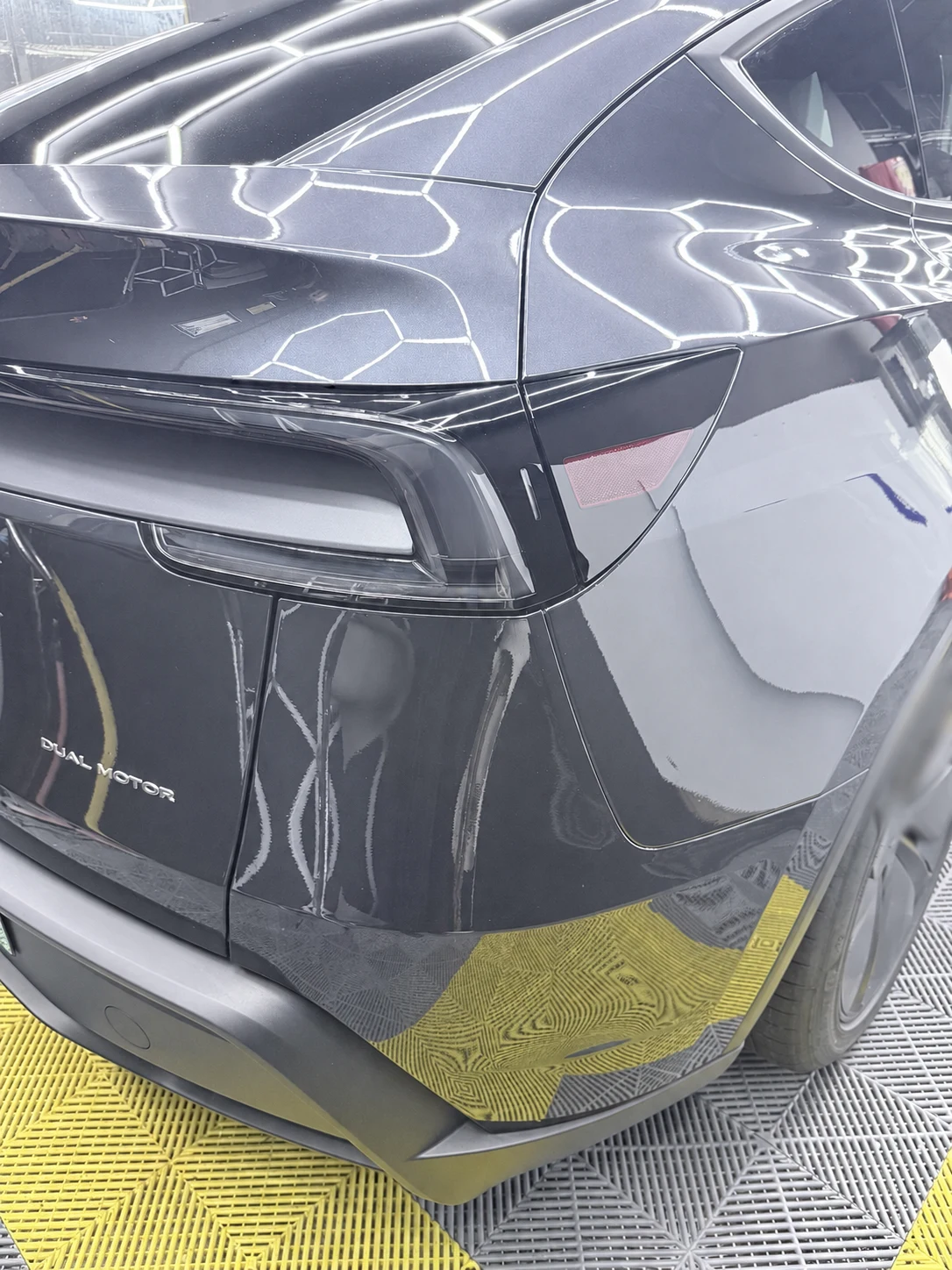 Finished rear quarter of a black Tesla Model Y after paint protection film installation